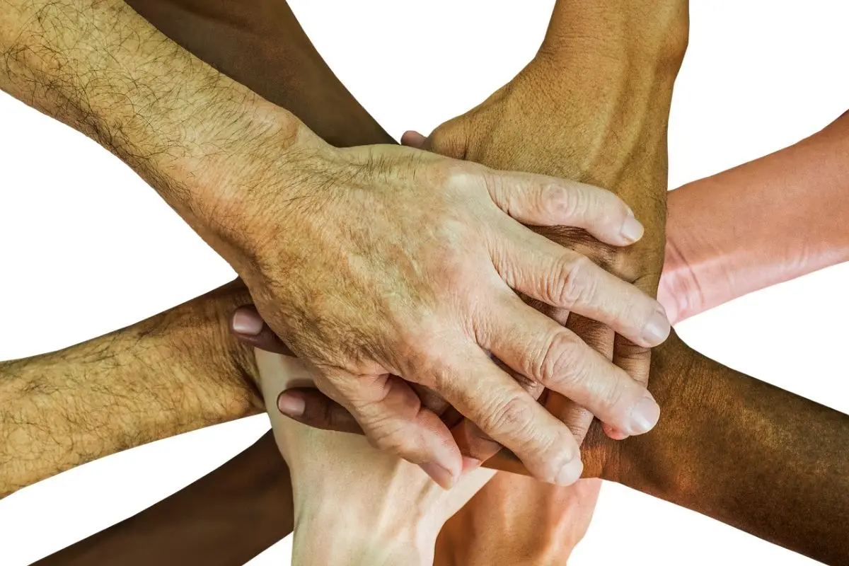 Diverse hands stacked together symbolizing unity and teamwork.